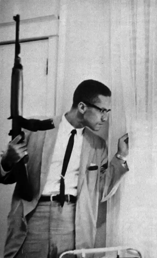 Malcolm X Peering Out Of A Window